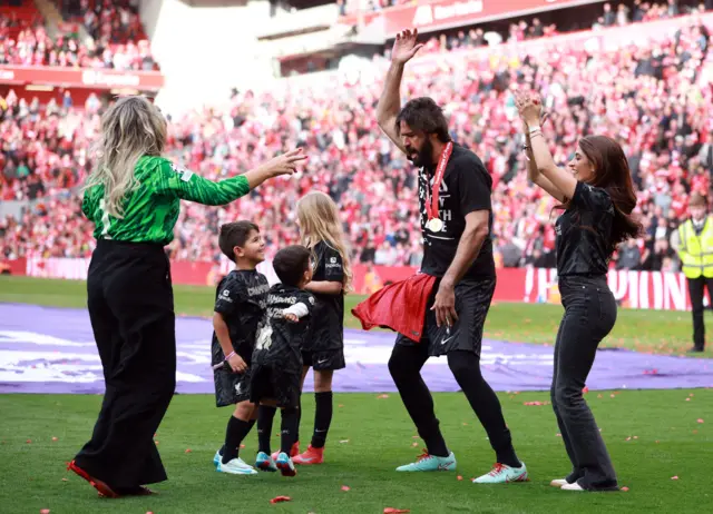 Alisson dances with three children on the pitch