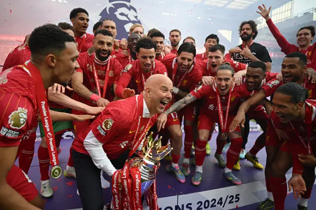 Arne Slot, Manger of Liverpool, lifts the Premier League trophy