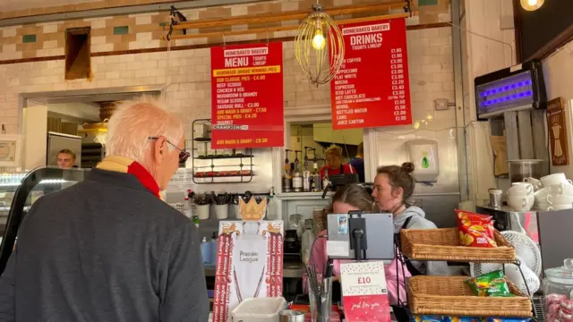 A man orders a pie at a pie shop