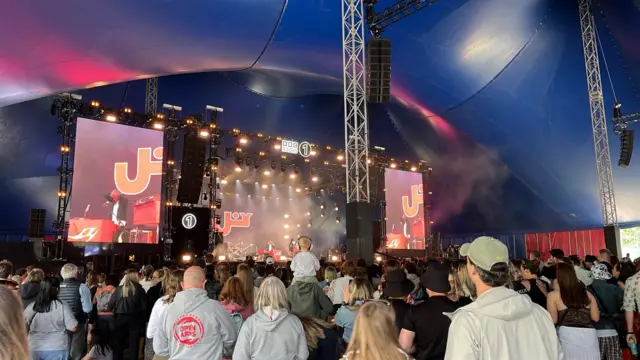 A crowd gathers around the New Music Tent to see Joy Crookes.