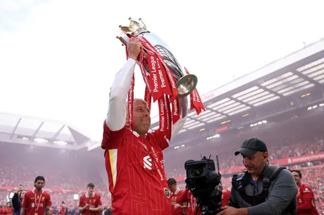 Arne Slot, Manger of Liverpool, lifts the Premier League trophy, as Liverpool are crowned the Champions of the Premier League, following the Premier League match between Liverpool FC and Crystal Palace FC at Anfield on May 25, 2025 in Liverpool, England.