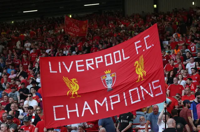 Liverpool fans holding up a champions banner