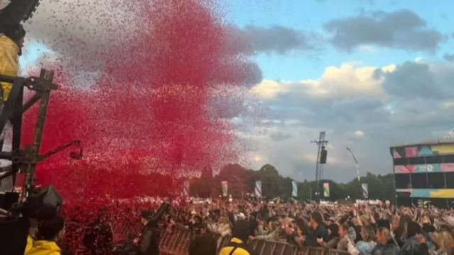 Confetti flying from stage onto large crowd