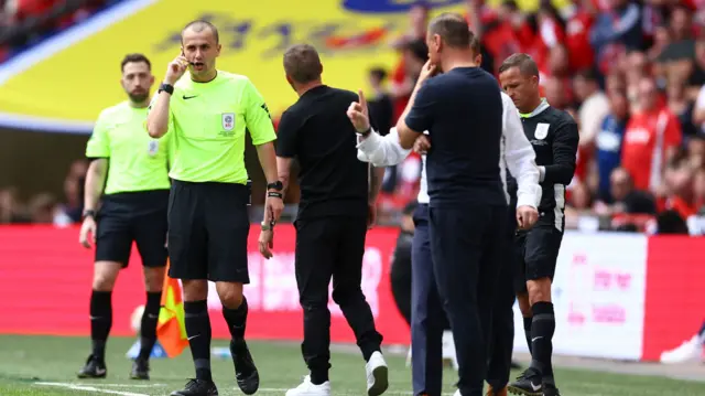 Referee Andrew Kitchen has communication problems with his microphone