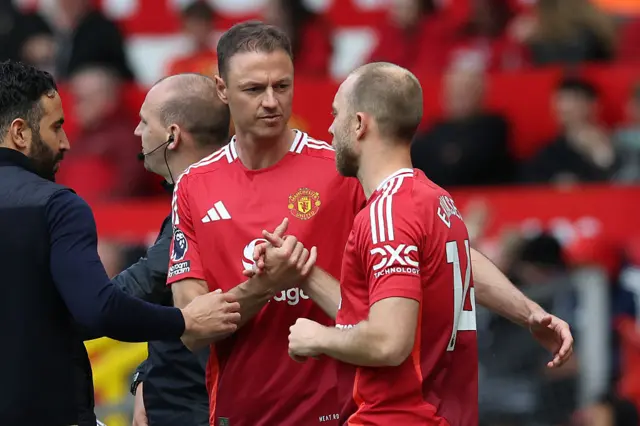Manchester United Northern Irish defender #35 Jonny Evans (L) and Manchester United's Danish midfielder #14 Christian Eriksen (R) prepare to come on to play their final games for United during the English Premier League football match between Manchester United and Aston Villa at Old Trafford
