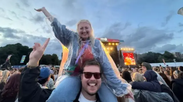 Kerry sat on Kurtis' shoudlers - stage behind them.