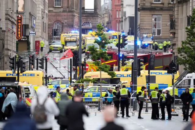 Dozens of ambulances fill a street in Liverpool, with police cordoning off where they have parked