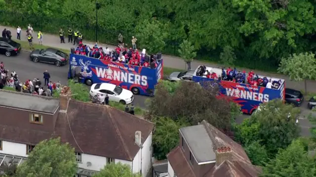 Two buses with open tops loaded full of palace players