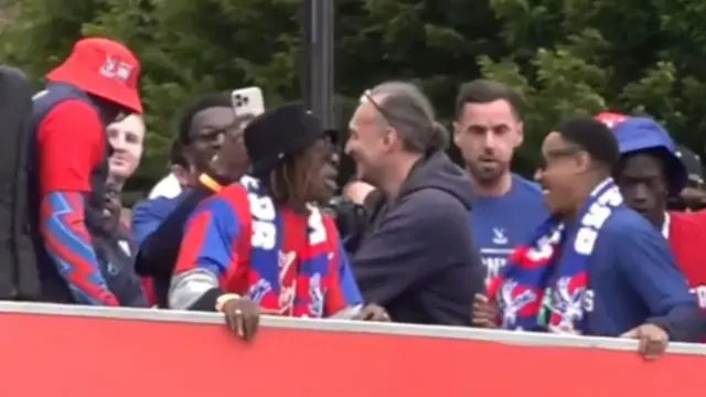 People stood on top of a bus laughing and looking at each other