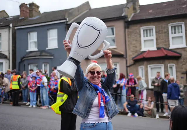 a woman holds up an inflated cup