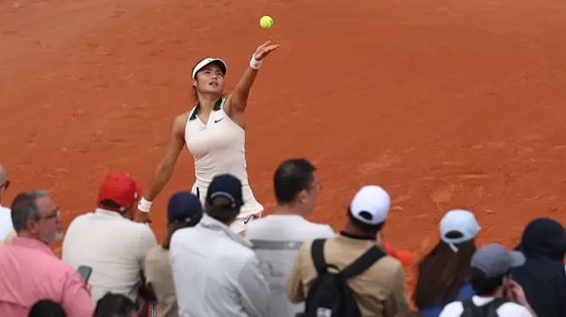 Emma Raducanu serves in front of a large crowd