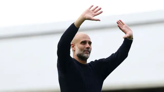 Pep Guardiola waves to Man City fans