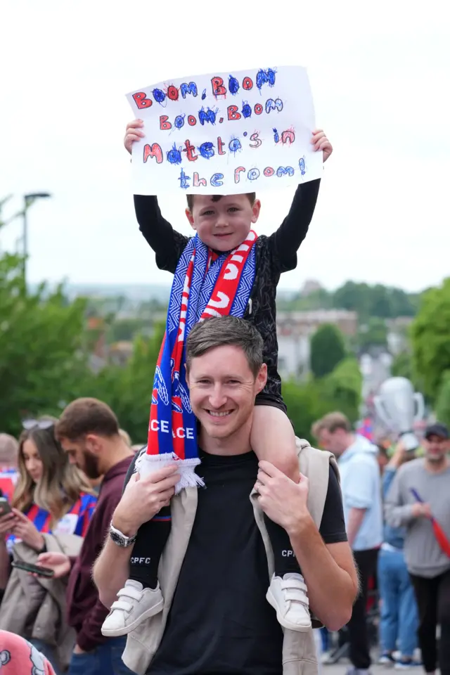 a child holds up a homemade poster