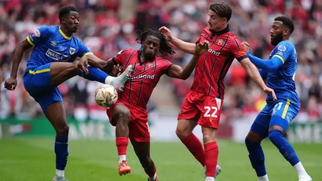 AFC Wimbledon and Walsall battle for the ball