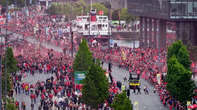 Hundreds of Liverpool fans line the road in the city centre ahead of the club's parade