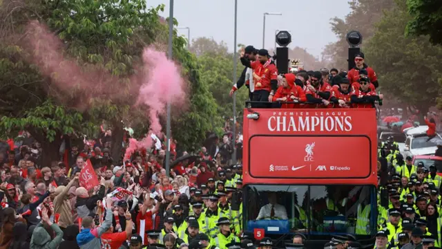 Mo Salah waves at Liverpool fans from the top of the open-top bus