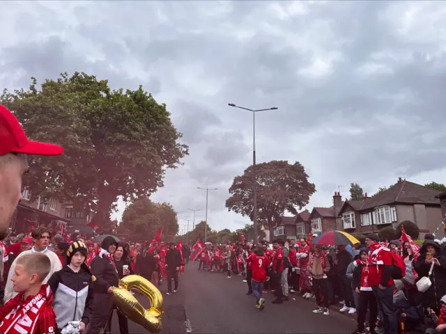 Liverpool fans line the streets