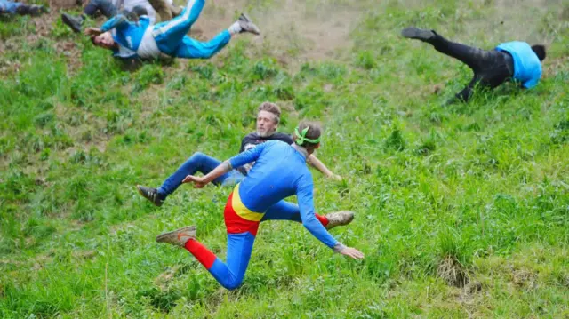 Luke Briggs in Superman suit tumbles down Cooper's Hill in Gloucestershire