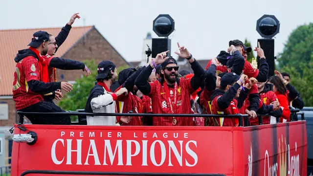 Liverpool goalkeeper Alisson Becker (centre) and team-mates on the team bus during the Premier League winners parade in Liverpool.