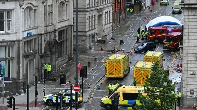 Police officers cover with an inflatable tent, behind a firefighter vehicle, the tents delimiting the scene of an incident in Water Street,