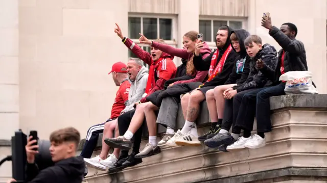 Liverpool fans on a high building waiting for the open-top parade