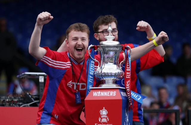 Crystal Palace fans Dominic and Nathan Henderson pose with the trophy during the Victory celebrations after a story written in The Guardian about a banner of their father in the stands after winning the FA Cup