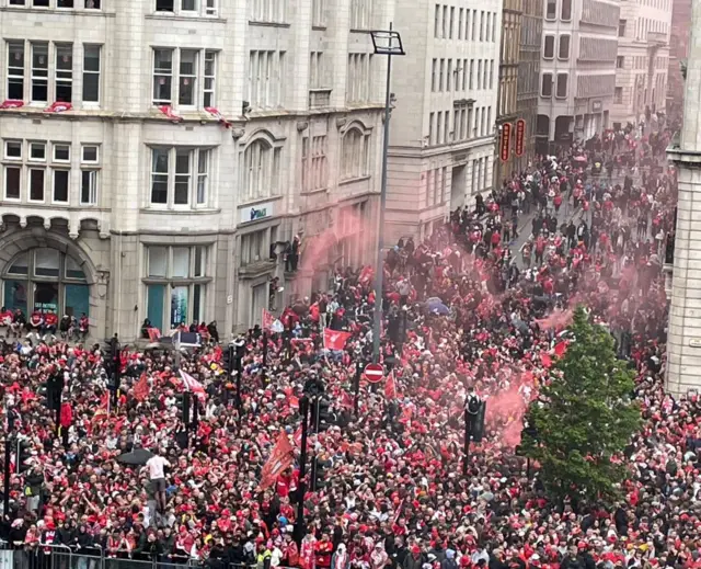 Large crowd of people in red and white on The Strand in Liverpool