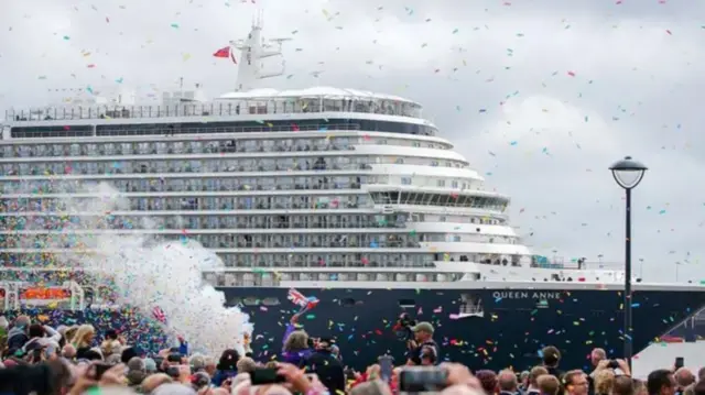 Members of the public attend the naming ceremony at Liverpool Pier Head for Cunard's Queen Anne with confetti being thrown and people flying Union Jack flags to celebrate.