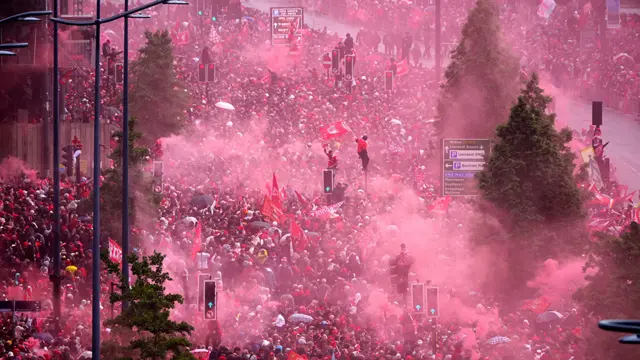 A sea of Reds fans amid Liverpool flags and red smoke from flares at Liverpool Waterfront