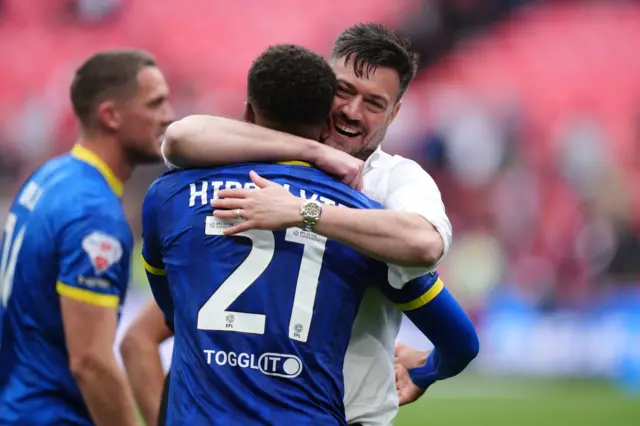 Wimbledon boss Johnnie Jackson celebrates