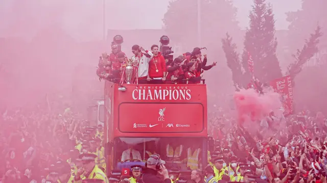 Liverpool fans watch on as the team bus approaches during the Premier League winners parade