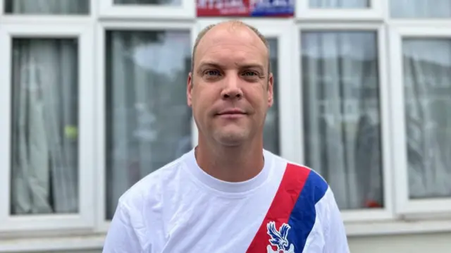 Billy Thompson wearing a white shirt with Crystal Palace eagle logo