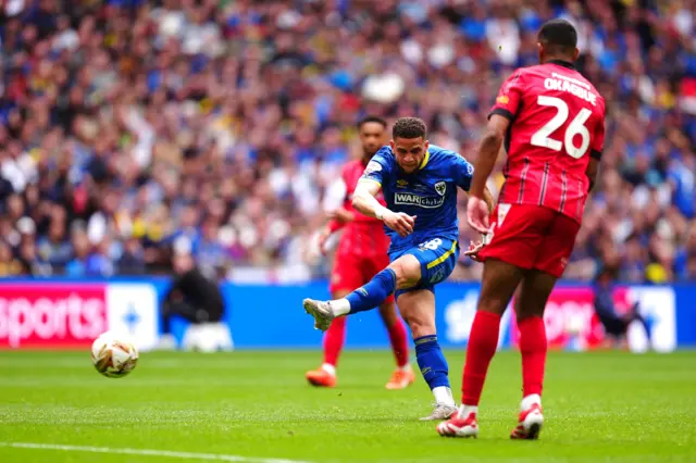 AFC Wimbledon's Marcus Browne (centre) attempts a shot towards goal