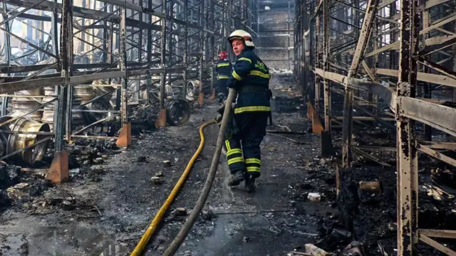 Ukrainian firefighters and rescuers work at the site of a damaged storage facility of a private factory following an overnight attack in Vasyshcheve, near Kharkiv, Ukraine.