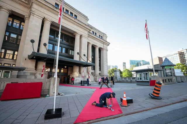 Workers roll out a red carpet in Ottawa
