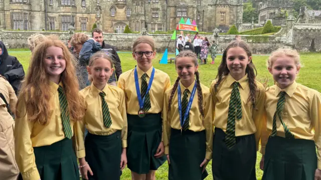 Criw o Ysgol y Dderwen yn llawen ar y maes