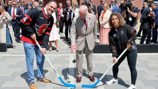 The King drops a black puck for a street hockey game.