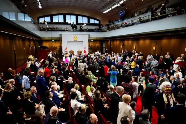 Rows of people seated inside the Senate