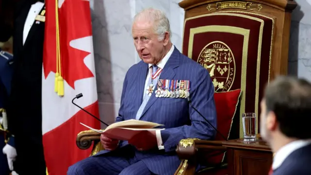 King Charles sits on the throne reading the speech to the Senate