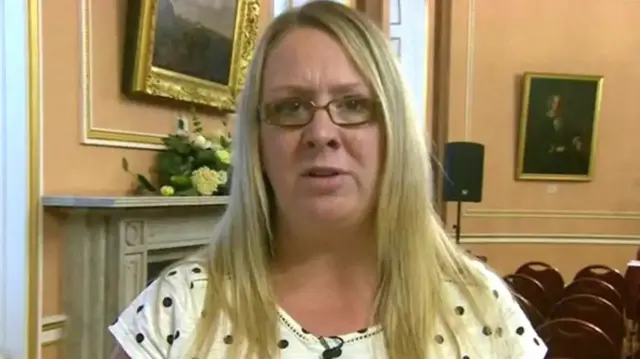 Charlotte Hennessy with long blond hair and glasses