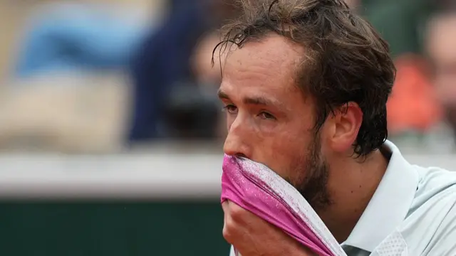 Daniil Medvedev wipes his face with his top