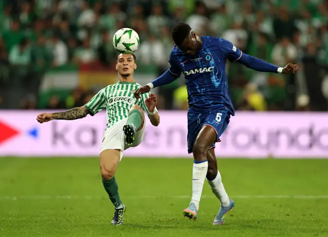 Antony of Real Betis controls the ball whilst under pressure from Benoit Badiashile