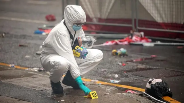 A forensic officer placing a number marking down on the pavement