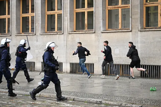 Polish riot police officers run to disperse clashes between fans of Chelsea and Real Betis