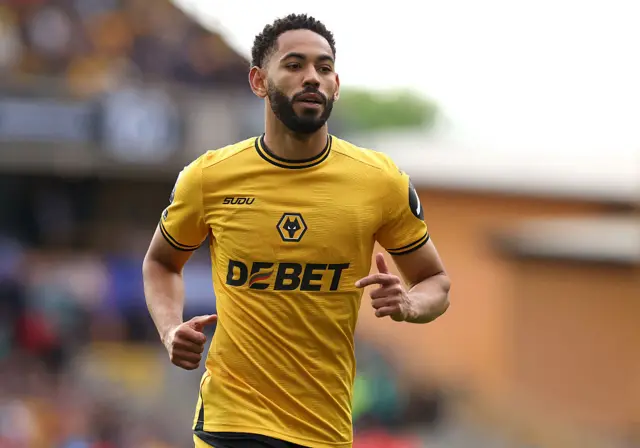 Matheus Cunha wearing a gold Wolves shirt