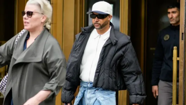 Nash leaving court in a black jacket and white cap