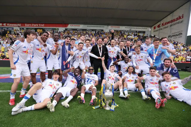Leeds players and boss Daniel Farke celebrate with the Championship trophy in front of their fans at Plymouth