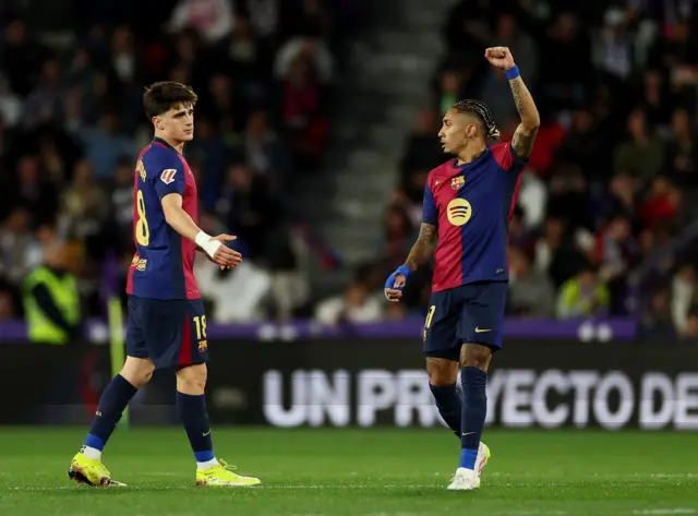 Raphinha holds his arm up to celebrate