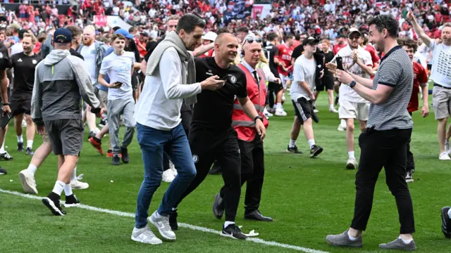 Bristol City boss Liam Manning is mobbed by fans at full-time