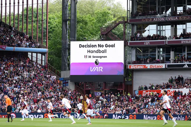 The LED screen displays a message from VAR which reads "Decision No Goal, Handball, 30 Sessegnon"